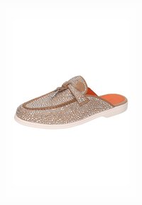 Zapato beige tipo slip-on con puntera redondeada, decorado con tachuelas plateadas, que presenta una parte superior texturizada y una plantilla naranja en contraste.