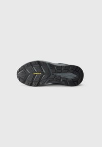 Black rubber shoe sole with deep treads, "Goodyear" in yellow, and "Skechers" embossed on a gray section in the center.