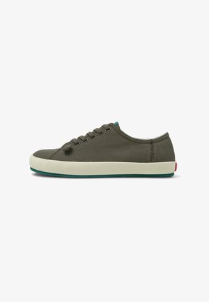 Olive green canvas sneaker with a white rubber sole, featuring tonal eyelets, round toe, and a small red logo detail on the heel.