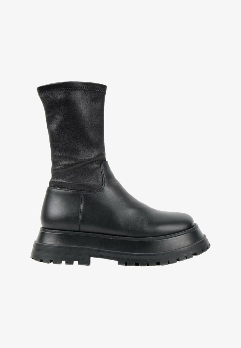 Botte mi-mollet en cuir noir avec une semelle en caoutchouc épaisse et texturée et un dessus lisse, vue de côté sur fond blanc.
