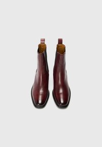 Burgunderfargede lær Chelsea-boots med en glatt overflate, elastiske sidelapper, rund tå og grep for enkel påkledning.