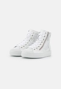High-top white sneakers made of textured leather and mesh, featuring silver zip accents and flat white soles, with perforated details.