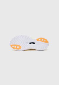 Suela de zapato blanca con un patrón ondulado, con tres acentos circulares naranjas y un logo central negro. El diseño es atlético y funcional.