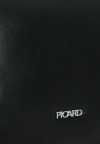Schwarze Lederhandtasche mit glatter Textur und subtilem Glanz. Verfügt über ein kleines silbernes "PICARD"-Logo auf der Vorderseite. Minimalistisches Design, rechteckige Form.