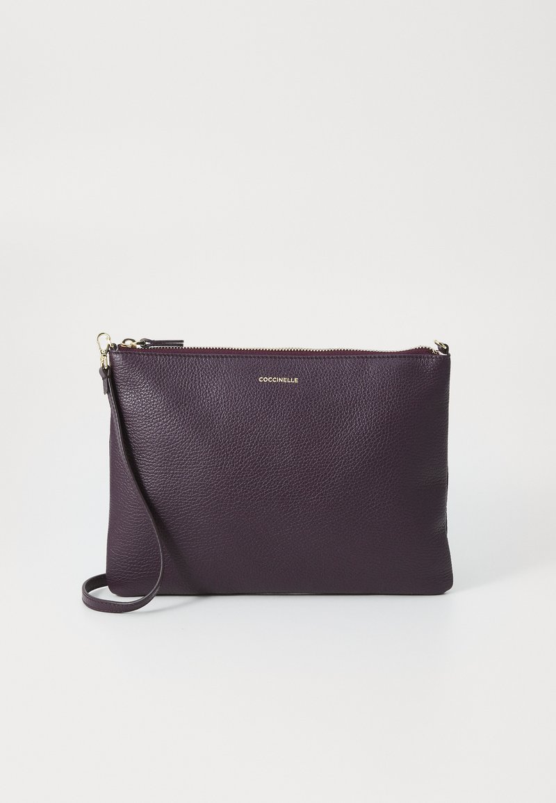 Purple leather clutch bag with a textured finish, featuring a top zipper and a detachable wrist strap. Gold brand logo on the front.