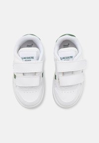 Sneaker bianche per bambini con accenti verde, dotate di tomaia in pelle liscia, due strap a strappo e dettaglio forato sulla punta.