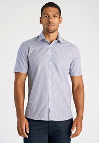 Camicia a maniche corte con bottoni di colore azzurro chiaro, con sottili righe e piccoli punti rossi. Presenta un colletto a punta e un orlo dritto.