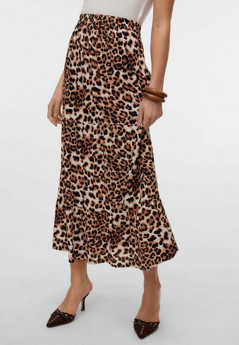 Gonna midi a stampa leopardata con vita elastica, fondo svasato e tessuto morbido. Indossata con scarpe con tacco marroni e un bracciale.