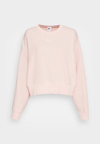 Ljus rosa Nike kortärmad sweatshirt med långa ärmar, ribbade muddarna och rund halsringning. Har en liten vit logotyp på bröstet.