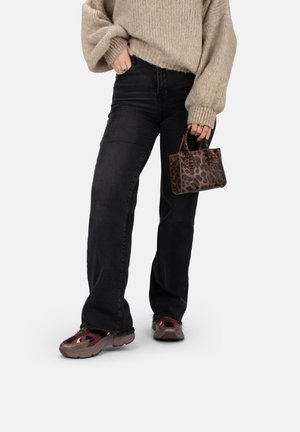 Leopard-print mini handbag with short handles, paired with oversized beige sweater and black wide-leg jeans. Sneakers with red accents.