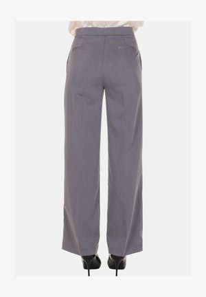 Pantaloni grigi a gamba larga con una texture liscia, dotati di due tasche posteriori e una vestibilità sartoriale, abbinati a scarpe con tacco.