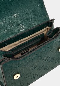 Groene, textuur afgewerkte leren handtas met gegraveerde patronen, accenten van goudkleurig beslag en beige binnenvakjes voor een goede organisatie.