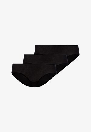 Trois culottes noires sans couture pour femmes disposées en pile sur un fond blanc.