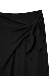 Jupe enveloppante noire avec un détail noué à la taille, présentant une texture lisse et une fermeture éclair sur un côté.