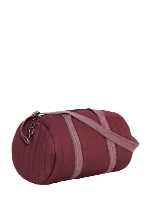 Sac cylindrique matelassé couleur marron avec des anses en tissu rose clair et une fermeture éclair latérale.
