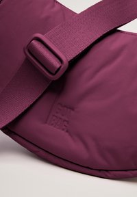 Borsa a spalla di colore viola ultramarino caratterizzata da un tessuto testurizzato, tracolla regolabile e logo "GOT BAG" impresso. Design compatto e arrotondato.