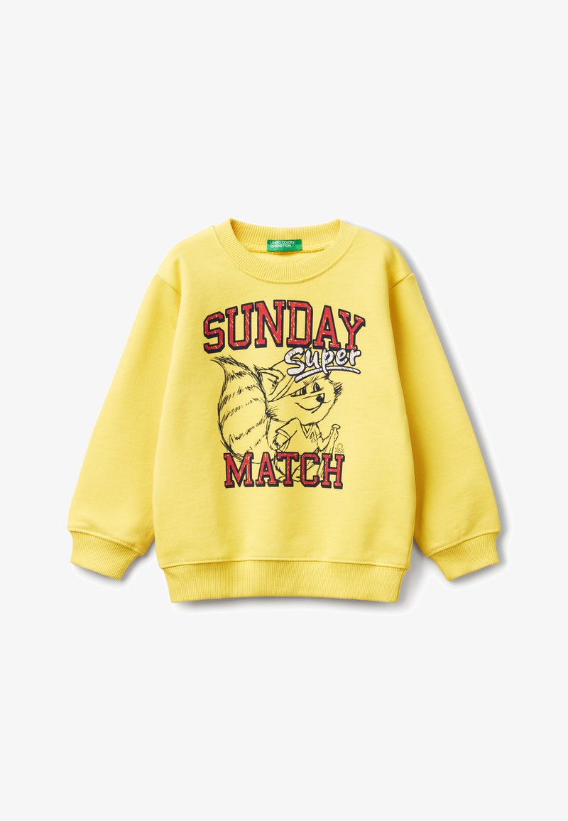 Sweat-shirt jaune en matériau doux, avec un col rond et des poignets côtelés. Il présente un graphique de renard en cartoon et le texte "DIMANCHE MATCH."