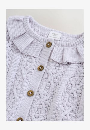 Helelilla kootud kampsun tekstuurse palmikumustriga, soonikuga krae ja kolme kulla toonis nööbiga esiäärel.