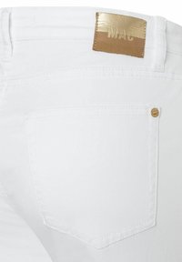 White denim jeans with a smooth texture and a fitted design. Features a gold and tan "MAC" label at the back and a single back pocket.