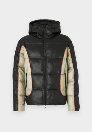 Casaco acolchoado em preto e creme, com capuz, bolsos laterais e costura contrastante em laranja. Textura suave com padrão acolchoado.