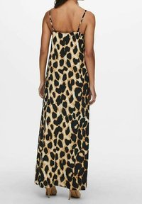 Maxikleid mit dünnen Trägern, ausgestattet mit einem schwarz-beigen Leopardenmuster. Leichter Stoff mit glatter Textur.