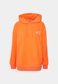 Jasnopomarańczowy kaptur z sznurkami i małym białym logo napisanym kursywą po lewej stronie klatki piersiowej, ściągacze przy mankietach i dolnej krawędzi.