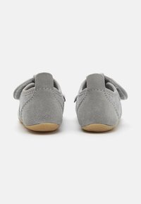 Šedé zamšové detské topánky so soft gumovou podrážkou, s uzatváraním na suchý zips a zaobleným dizajnom podpätku. Hladká textúra.