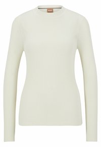 Ribbad långärmad topp i off-white, med en rundad halsringning och en tight passform. Tillverkad av ett mjukt, elastiskt tyg.