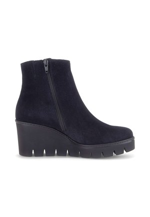 Black suede ankle boot with side zipper, wedge heel, and chunky treaded sole, shown from the outer side on a white background.