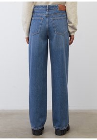 Szerokie niebieskie dżinsy z wysokim stanem, wykonane z denimu. Charakteryzują się skórzaną metką z tyłu oraz dwiema kieszeniami z tyłu. Teksturowane wykończenie.