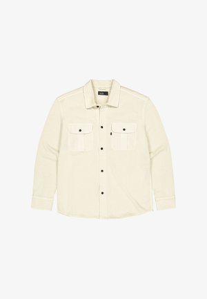 Lange mouwenshirt van lichtbeige stof met twee borstzakken, zwarte knopen en een kraag. Heeft contrasterende stiksels en opgerolde manchetten.