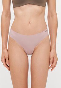 Roze naadloze onderbroek met een gladde textuur en een dunne tailleband, voorzien van een klein logo aan de zijkant. Eenvoudig, laag uitgesneden ontwerp.