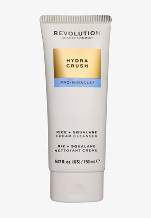 Tubetto di Revolution Beauty London Hydra Crush Pro-Miracle detergente cremoso al riso e squalano, 150 ml, con etichetta dorata e blu su sfondo bianco.