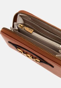 Portafoglio in pelle marrone con hardware dorato, dotato di più slot per carte, una tasca con zip e una superficie texture. Interno di colore chiaro.