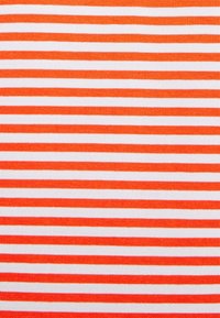 Gestreepte stof met afwisselend brede oranje en witte strepen, met een textuur in levendige, contrasterende kleuren.