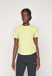 Maglietta atletica a maniche corte di un vivace giallo, realizzata in un tessuto liscio. Presenta un colletto rotondo e un piccolo logo sul petto.