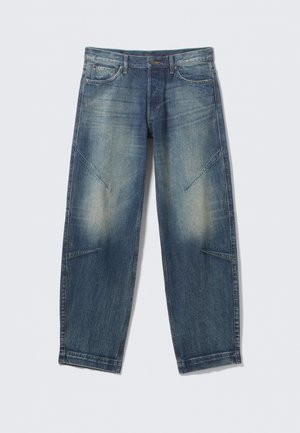 Blaue, verwaschene Denim-Jeans mit Fronttaschen, einem Knopf- und Reißverschluss und schrägen Nahtdetails an den Beinen.