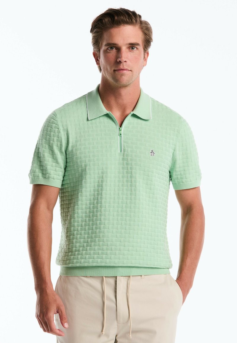 Hellgrün Poloshirt mit strukturiertem Muster, kurzen Ärmeln und einem halben Reißverschluss am Kragen. Verfügt über weiße Akzente und ein kleines Logo auf der linken Brust.