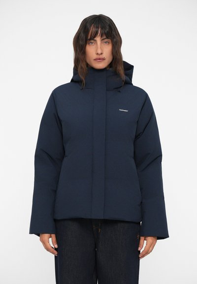 Marineblauwe pufferjas met hoge kraag en capuchon, voorzien van een ritssluiting aan de voorkant en elastische manchetten. Glad materiaal met minimale branding.