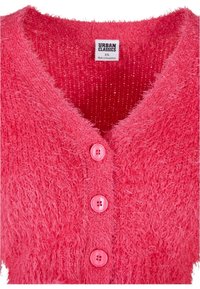 Cardigan en maille rouge duveteux avec trois boutons et une étiquette indiquant Urban Classics, taille XS, fabriqué au Bangladesh.