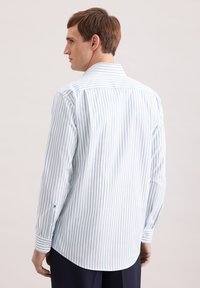 Herren-Langarmhemd mit Knopfleiste in hellblauen und weißen Streifen. Hergestellt aus glattem Stoff mit spitzem Kragen und abgerundetem Saum.