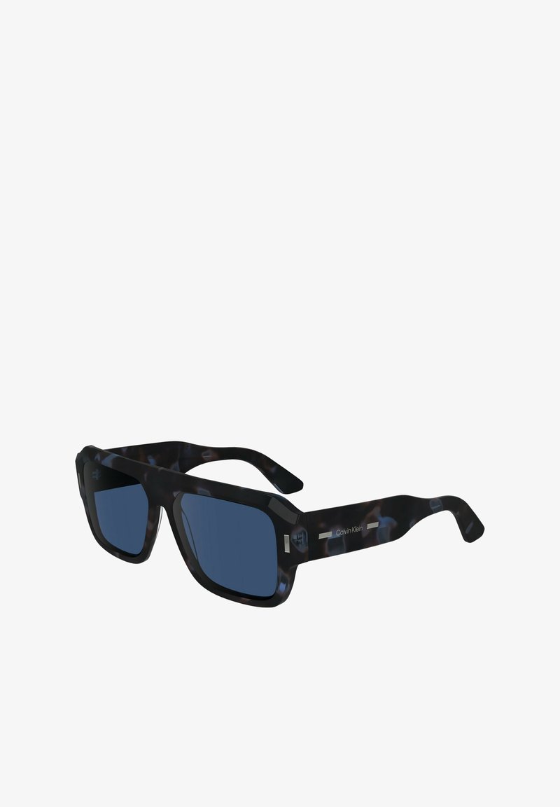 Occhiali da sole con una montatura in plastica tartarugata nera e blu, lenti quadrate e dettagli metallici con il logo Calvin Klein sulla tempia.