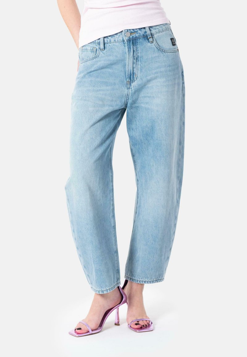 Jeans in denim azzurro chiaro con una vestibilità dritta, dotati di chiusura con bottone, passanti per cintura e leggeri effetti di sbiadimento; abbinati a tacchi rosa con cinturini.