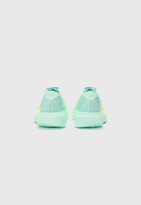 Mintgrüne Sneakers mit gelben Akzenten, Obermaterial aus Mesh und Synthetik, abgerundete Ferse, weiche Textur und markantes Logo auf der Fersenschlaufe.