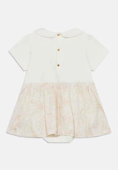 Λευκό φόρεμα με κοντά μανίκια που διαθέτει μονόχρωμο πάνω μέρος και μπεζ φούστα με υφή και σχέδιο. Κλείσιμο στο πίσω μέρος με χρυσά κουμπιά. Λεπτομέρεια γιακά.