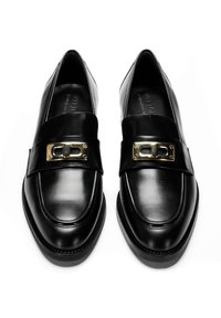 Mocassini in pelle nera con finitura liscia, una fascia larga con una fibbia dorata e un design classico con punta rotonda.