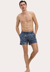 Marine zwemshorts met een wit topografisch patroon, elastische tailleband en zijzakken. Gemaakt van lichtgewicht, snel drogend materiaal.