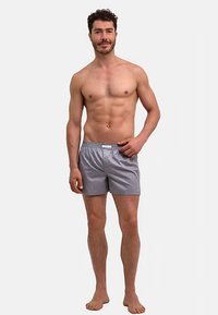 Maillots de bain pour hommes à rayures bleu clair et blanc, dotés d'une ceinture élastique et d'une coupe décontractée, avec des poches latérales.