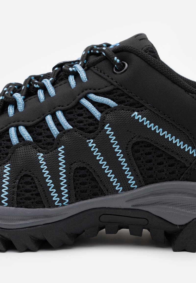 Zapato de senderismo negro con costuras azules, paneles de malla y suela de goma. Cuenta con un sistema de cordones prominente con ojales y un diseño texturizado duradero.