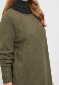 Maglione a maglia verde oliva con scollo a girocollo, polsini a costine e vestibilità morbida. Texture morbida con dettagli minimi e un leggero effetto melange.